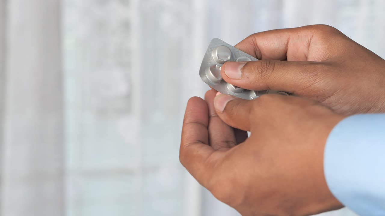 Person holding a blister pack of pills