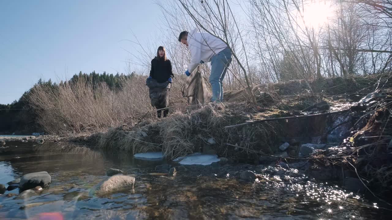 해변에서 플라스틱을 청소하는 팀워크: 자원봉사자들이 쓰레기 봉투에 쓰레기를 모으고, 플라스티크 오염과 환경 문제 개념: 플래스틱에서 자연을 자발적으로 청소하는 것, 지구를 녹색화하는 것