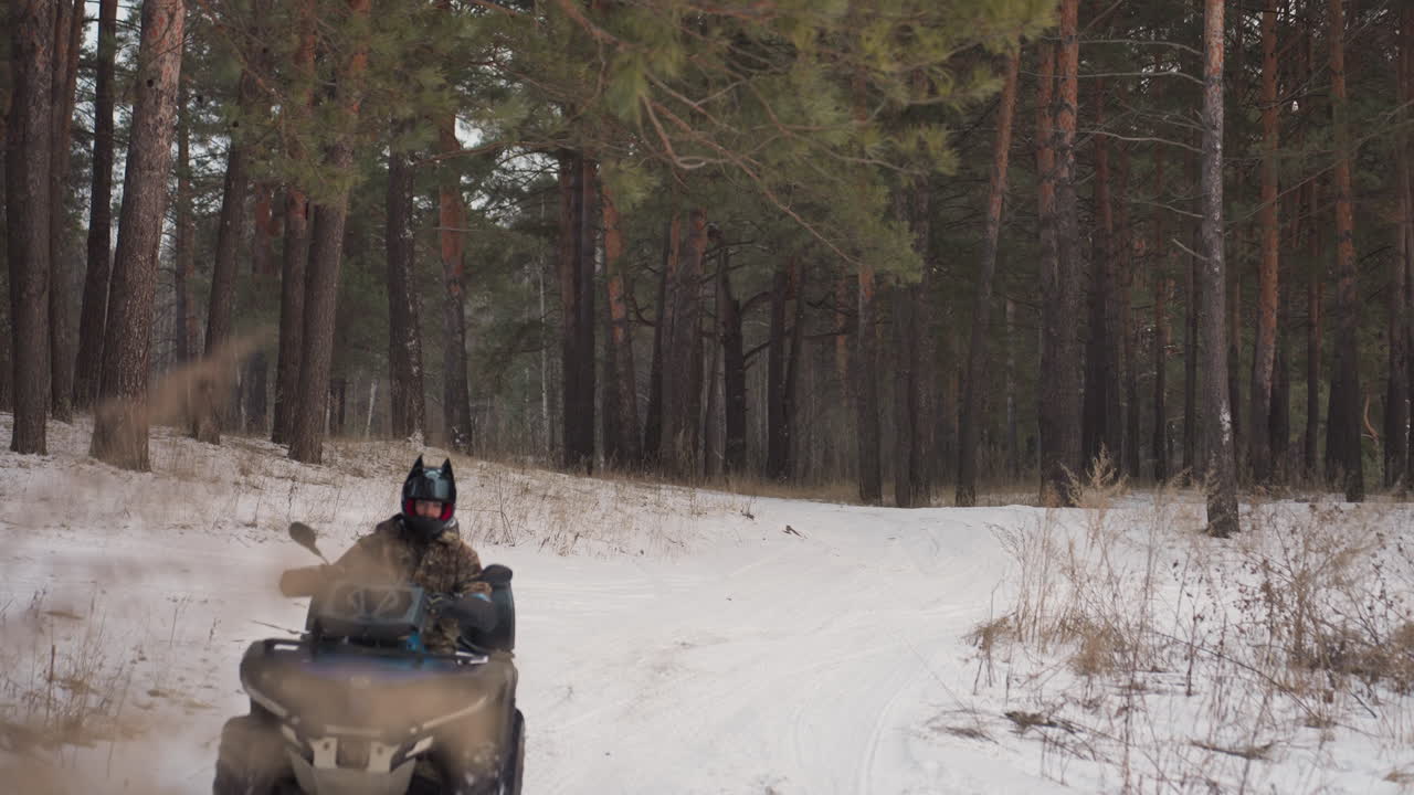Un pilota sfreccia rapidamente su un sentiero forestale innevato. Un esploratore di montagna si lancia agilmente attraverso un terreno di neve fresca. Un pilota di quad, spinto dall'adrenalina, naviga sentieri boschivi ghiacciati con abilità aggressiva.