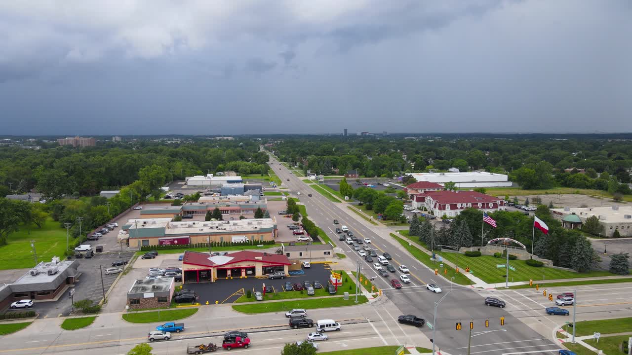 Dark blue storm clouds flow over small town of Troy in Michigan, aerial view