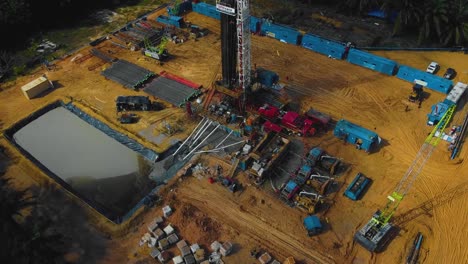 estructura cinematográfica de plataformas de perforación y reacondicionamiento en tierra y equipo de plataformas para la exploración y explotación de petróleo en medio de la jungla rodeada de palmeras durante la puesta de sol