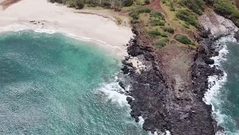 Drohnenantenne-über-Klippe,-Weißer-Sand,-Blauer-Wasserstrand