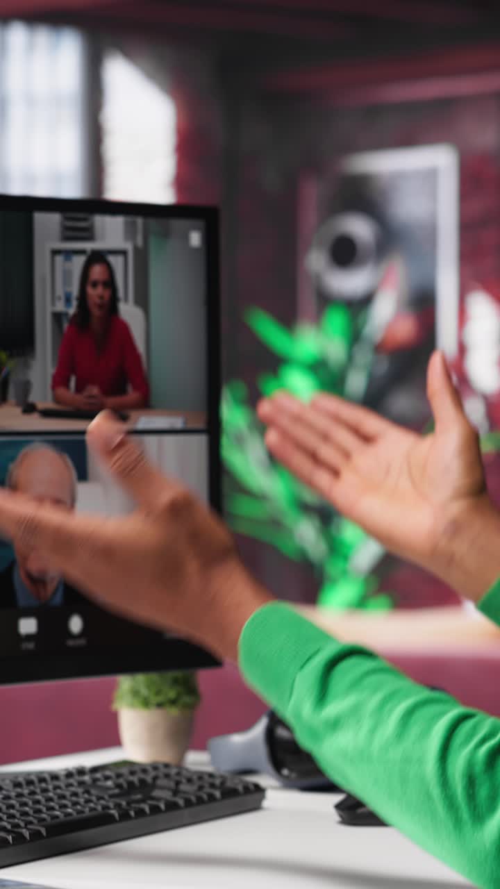 Video verticale. Lavoratore da remoto che guarda il monitor del PC e discute con i colleghi.