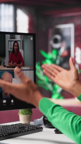 vertical video remote worker looking at pc monitor discussing with coworkers