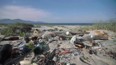 miscellaneous waste of domestic plastic, bottles, and fishing equipment trash pollute white sandy beach