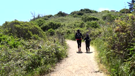 Mom-and-son-holding-hands-while-going-on-a-nature-walk