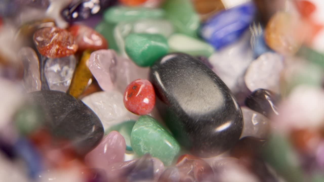 A close-up view of vibrant chakra stones magnified, highlighting their colors and textures in a 13-second video