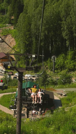 joyful family rides cable car with incredible view of nature beauty. enjoying leisure time together on summer holiday. hotel area surrounded by mountains and forest slow motion