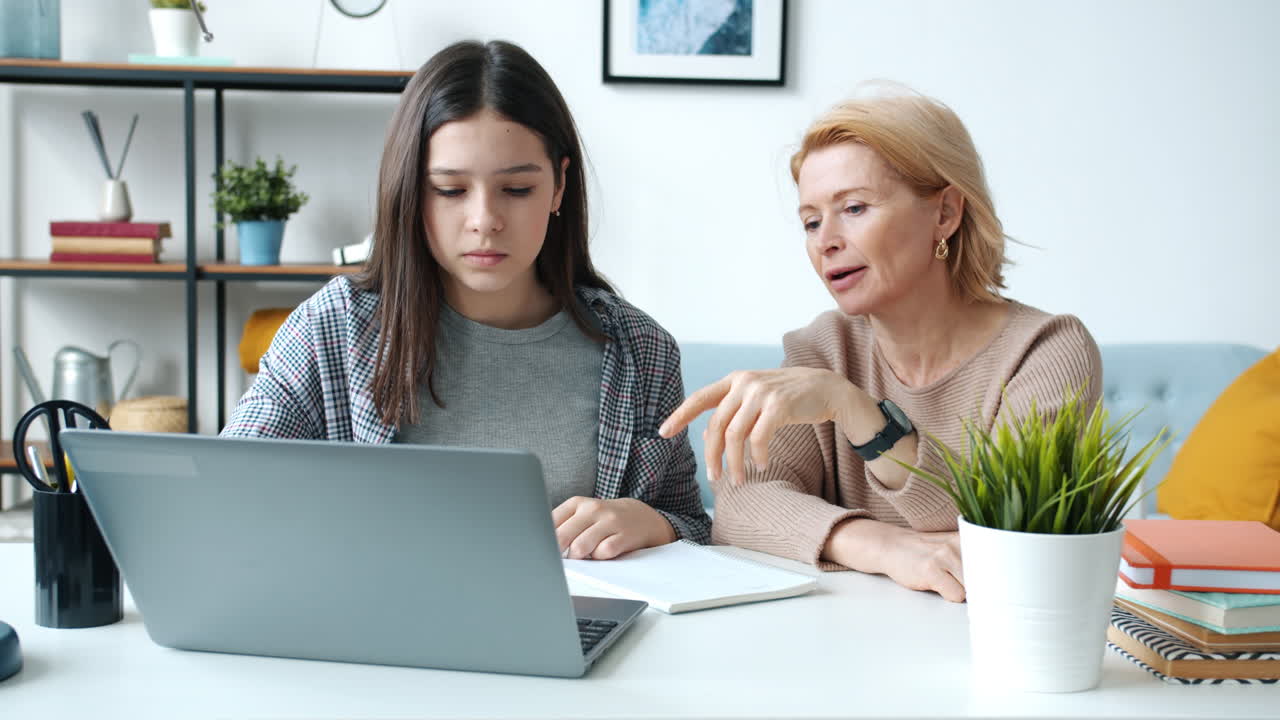 Teenage Girl and Adult Woman Studying Together