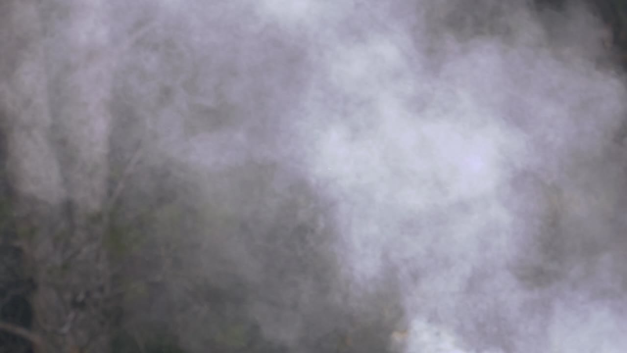 Column of white smoke rising from a chimney and slowly dispersing