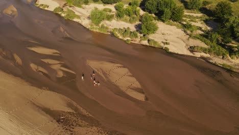 Family-walking-on-river-shores,-Cordoba-in-Argentina