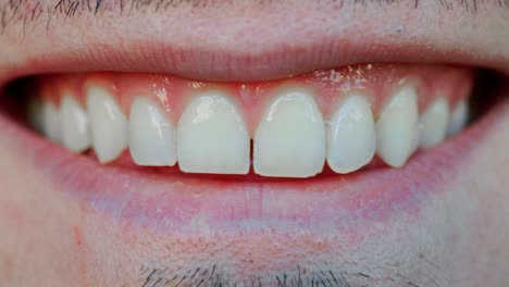 a close up of a man smiling with a small gap between in teeth