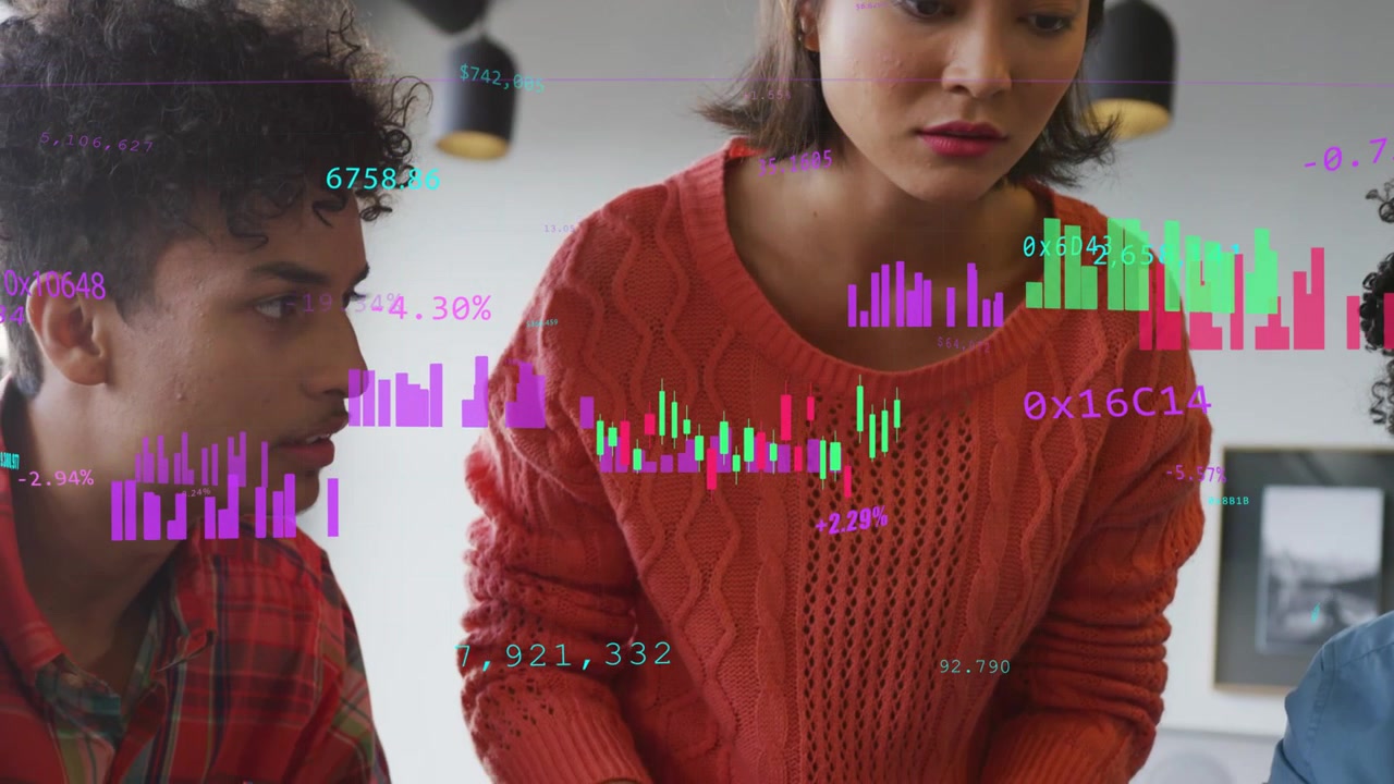 Team leaning over table accepting pen and noting finance review charts with candlesticks overlaying