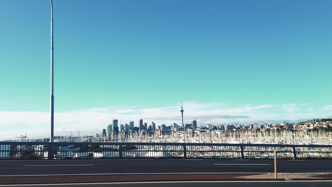 Car view looking out passenger seat towards skyline of Auckland with Sky Tower