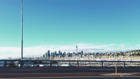 car view looking out passenger seat towards skyline of auckland with sky tower