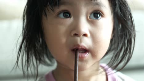 young 2 year old malaysian girl drinking from a straw - food dinner nutrition and health concepts