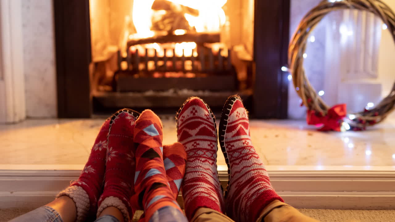 벽난로 앞에서 휴식을 취하는 크리스마스 양말을 입은 아프리카계 미국인 가족의 발의 애니메이션