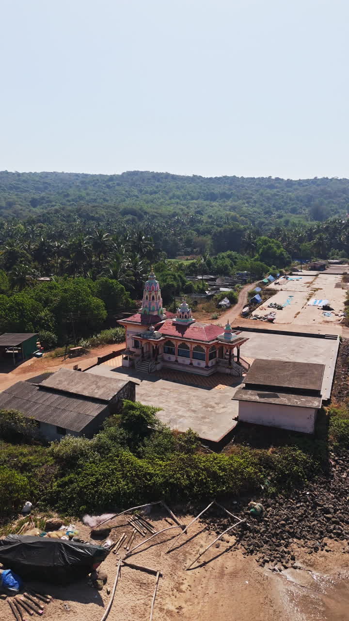 Aerial portrait orbiting the Hanuman Mandir Hindu temple, in sunny Guhagar, India