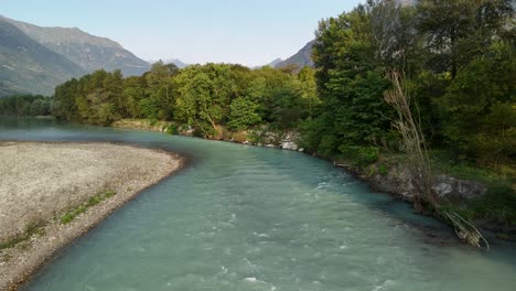 the peaceful toce river flows through the center of a lush forest, surrounded by mountains in ansola, italy, creating a serene and picturesque natural landscape.
