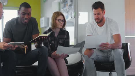 Young-mixed-race-business-team-discussing-over-documents-in-modern-office-4k