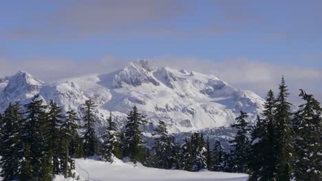 Snow-Covered-Massif-Rock-Mountains-With-Conifer-Trees-During-Winter