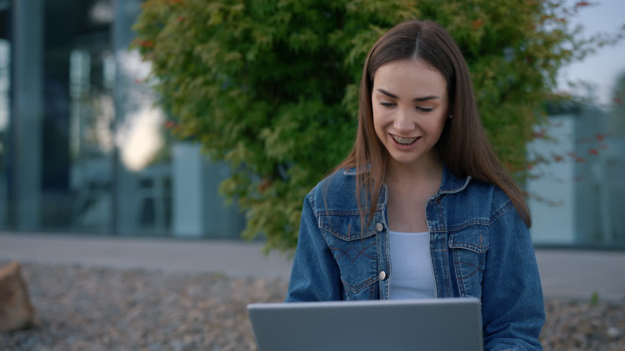 mujer joven trabajando en una computadora portátil al aire libre