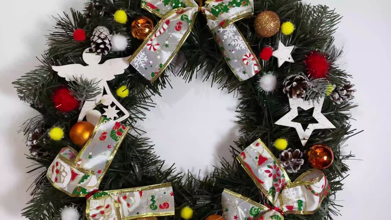 corona de navidad que decora la puerta principal para las fiestas hechas de abeto, arcos de plata, estrellas y bolas de navidad aisladas sobre un fondo blanco