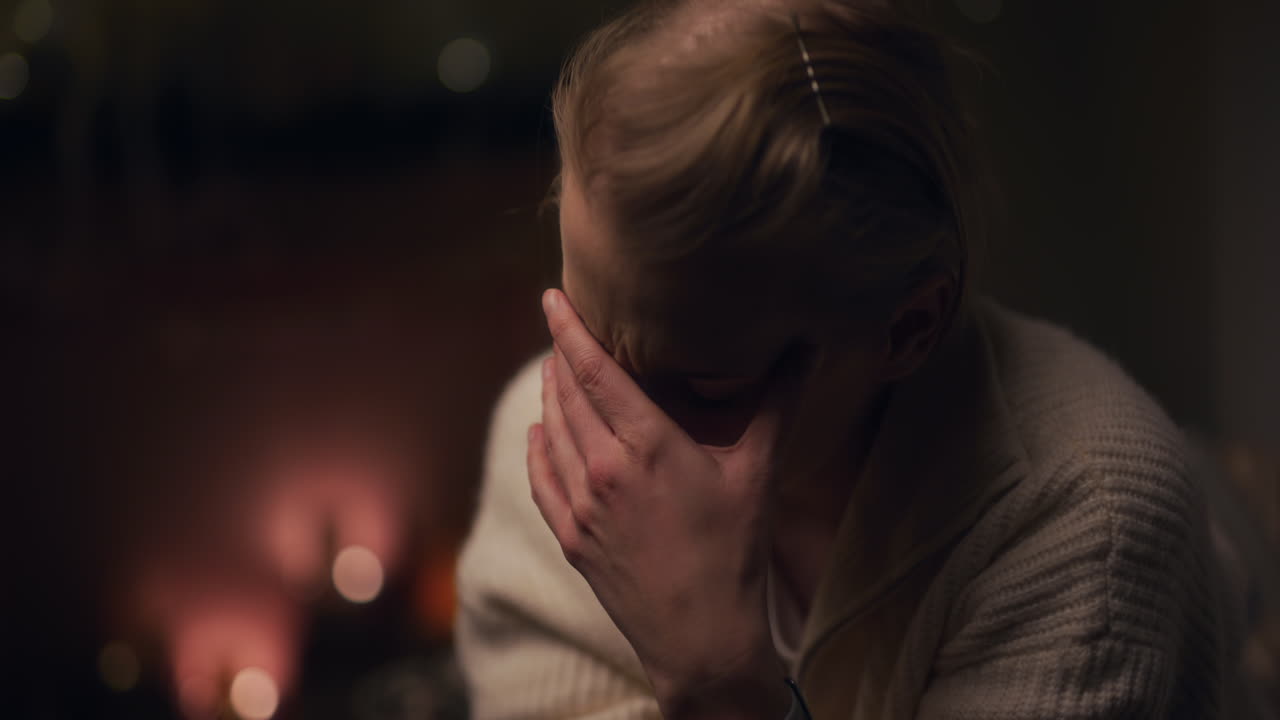 una mujer recibe un mensaje de texto de malas noticias y se deprime por la noche