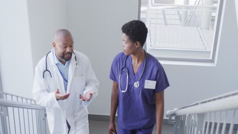 African-american-male-and-female-doctors-talking-at-hospital