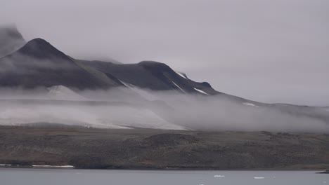 landscape and coastline scenery of island in arctic circle, hills and fog above tundra