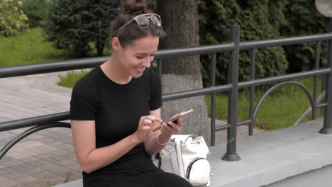 mujer usando el teléfono en un parque