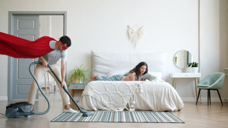 funny couple cleaning bedroom