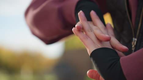 hand view gym lover rolling fists gently in outdoor autumn urban setting with soft sunlight illuminating skin texture and movement as part of warm up routine for exercise preparation and calm focus