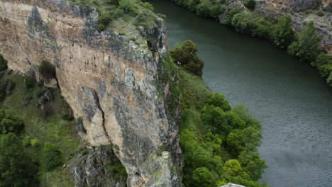 calm water of duraton river with rugged landscape of canyons in hoces del rio duraton natural park