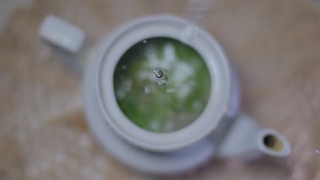 boiling water is poured from high into the teapot