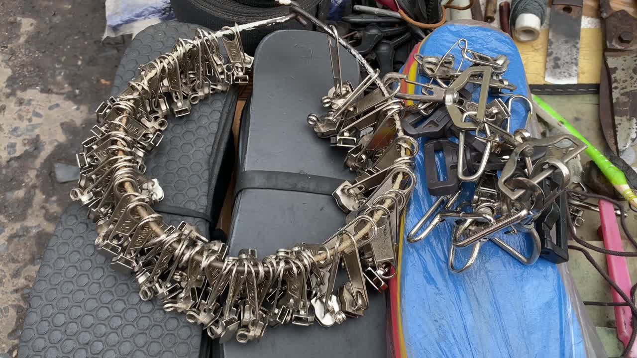 시장에서 가난한 코블러가 판매하는 여러 개의 지퍼 머리나 슬라이더의 클로즈업 샷