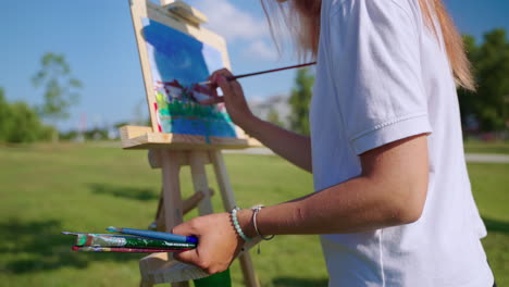 woman painting a landscape outdoors