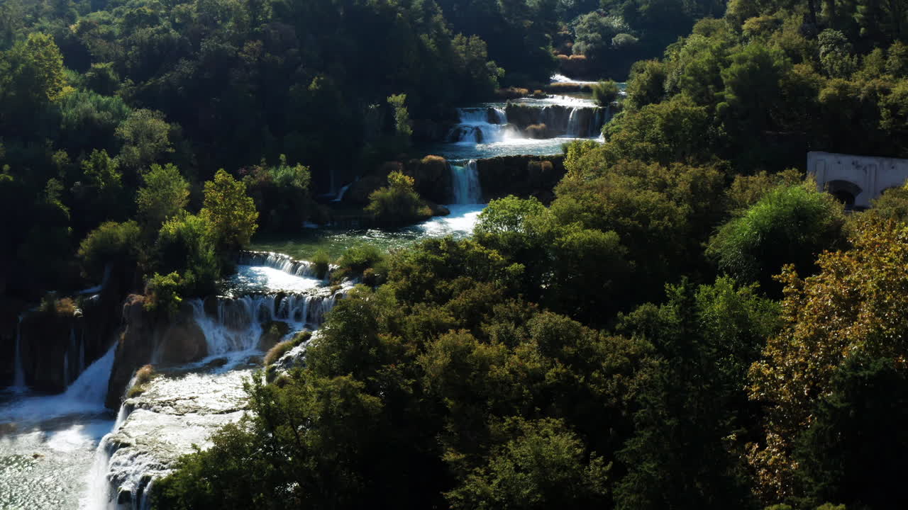 Acque soleggiate della Cascata Skradinski Buk lungo il fiume Krka, circondata da fitti alberi in estate