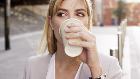 Attractive-blonde-business-woman-using-smartphone-commuting-in-city-london