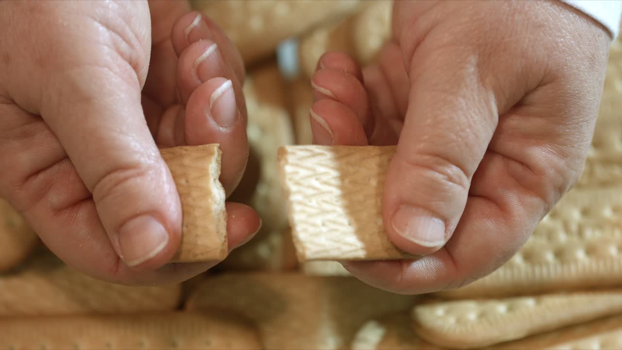 옥수수 전분 웨이퍼를 반으로 깨는 여성 손 클로즈업