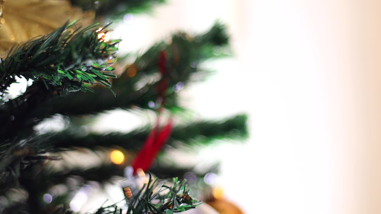 manos de niña poniendo una pelota en el árbol de navidad