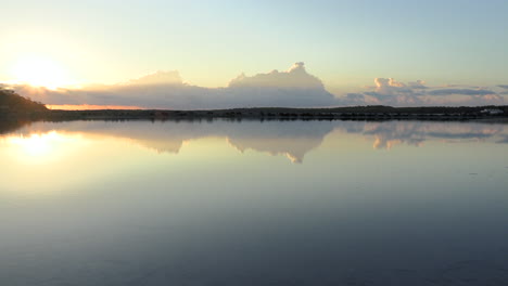 Pan-Suave-De-Las-Salinas-De-Ibiza-Con-Luces-De-Amanecer-Reflejadas-En-El-Agua,-Ibiza,-España