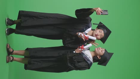 dos graduados tomando una selfie