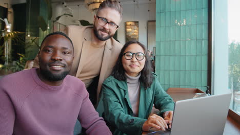 portrait of cheerful multiethnic business team in cafe