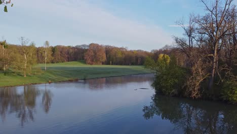 drone shot of a lake in the morning in a park, green belt, cologne, germany