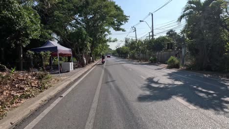 a cyclist pedals along a quiet suburban street.