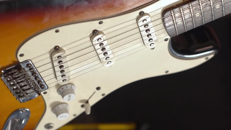 Chitarra elettrica su stativo con ombre in movimento, primo piano.
