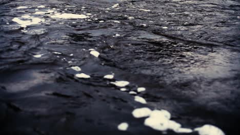 a steep dark river with a rock