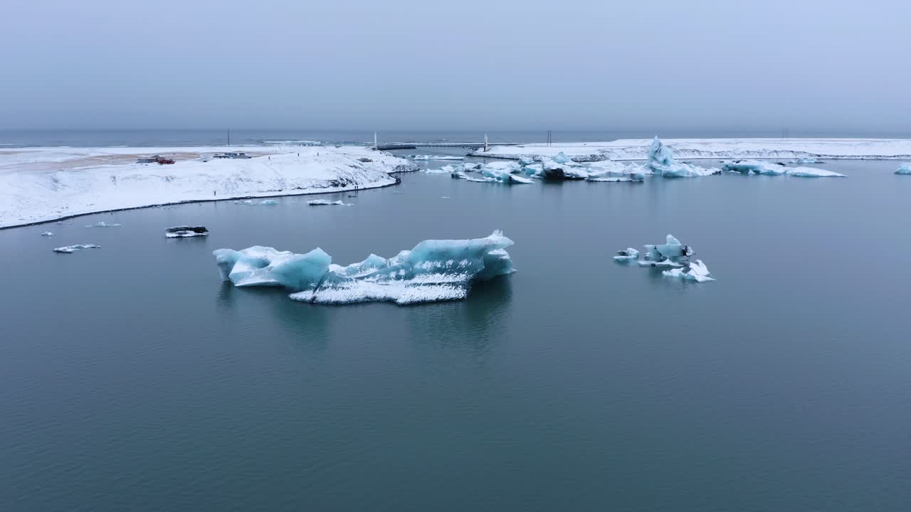 아이슬란드에서 안개가 자욱한 날 동안 jökulsarlon의 빙하 강 석호에서 빙산의 공중 역방향 비행