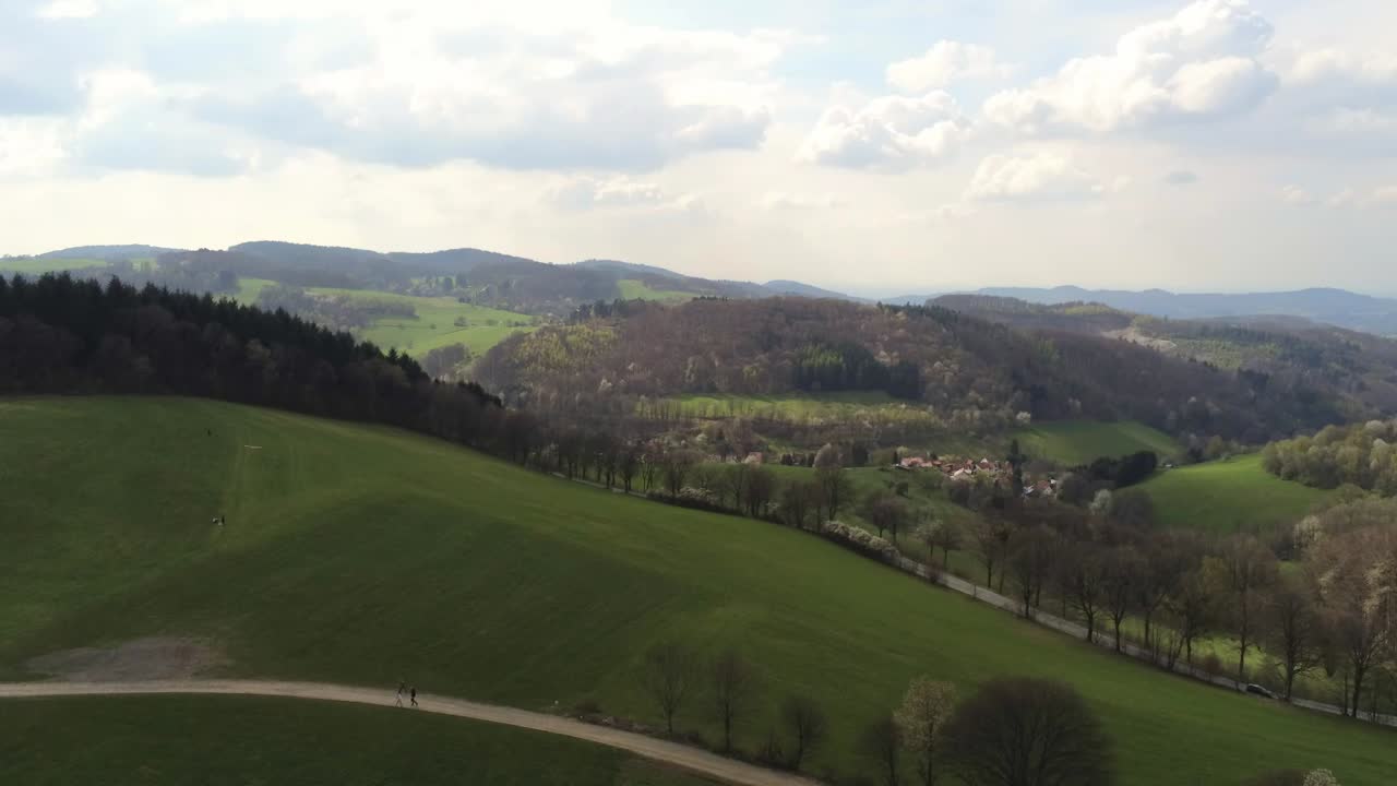 Discesa su una splendida collina tedesca con traffico sulla strada e persone che camminano.